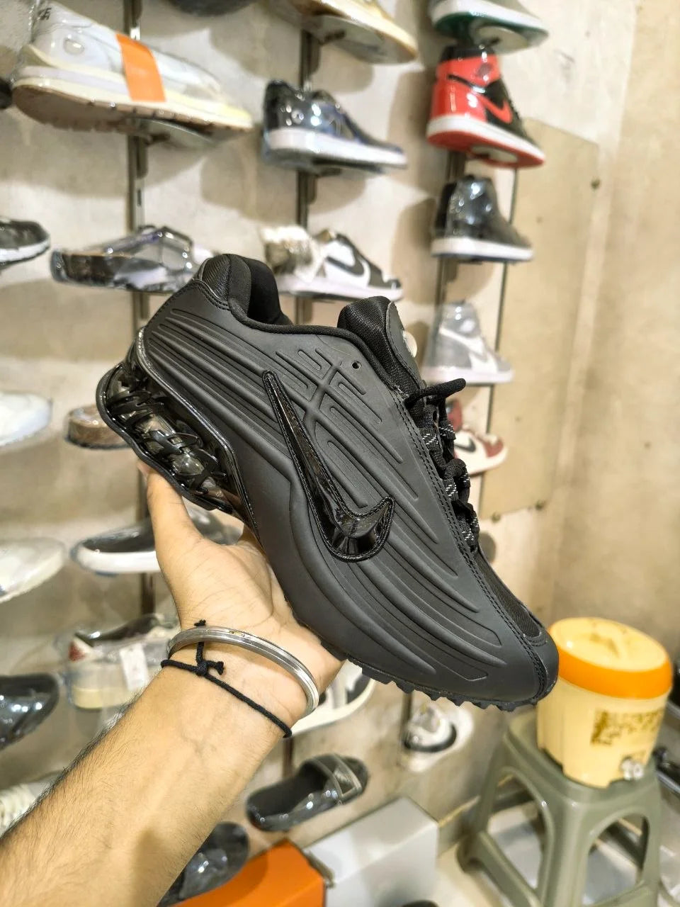 Black Nocta-style sneakers with layered upper design