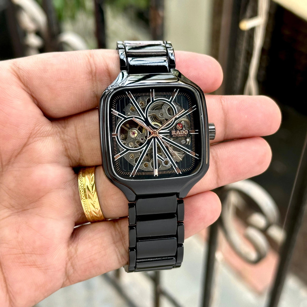 Automatic skeleton-style watch with black metal bracelet