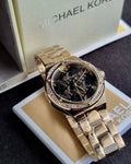 Women’s analogue watch with black dial and gold strap